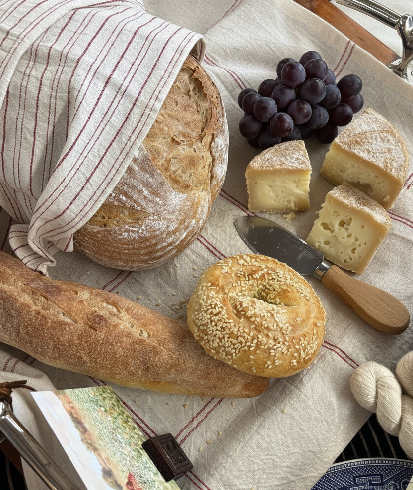 A styled picnic-style food arrangement on a striped Kala Cotton charcuterie liner