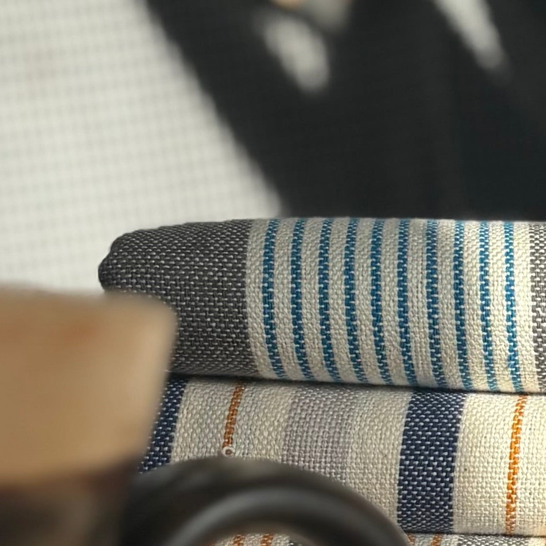 Stack of folded striped fabric on a chair with blurred background