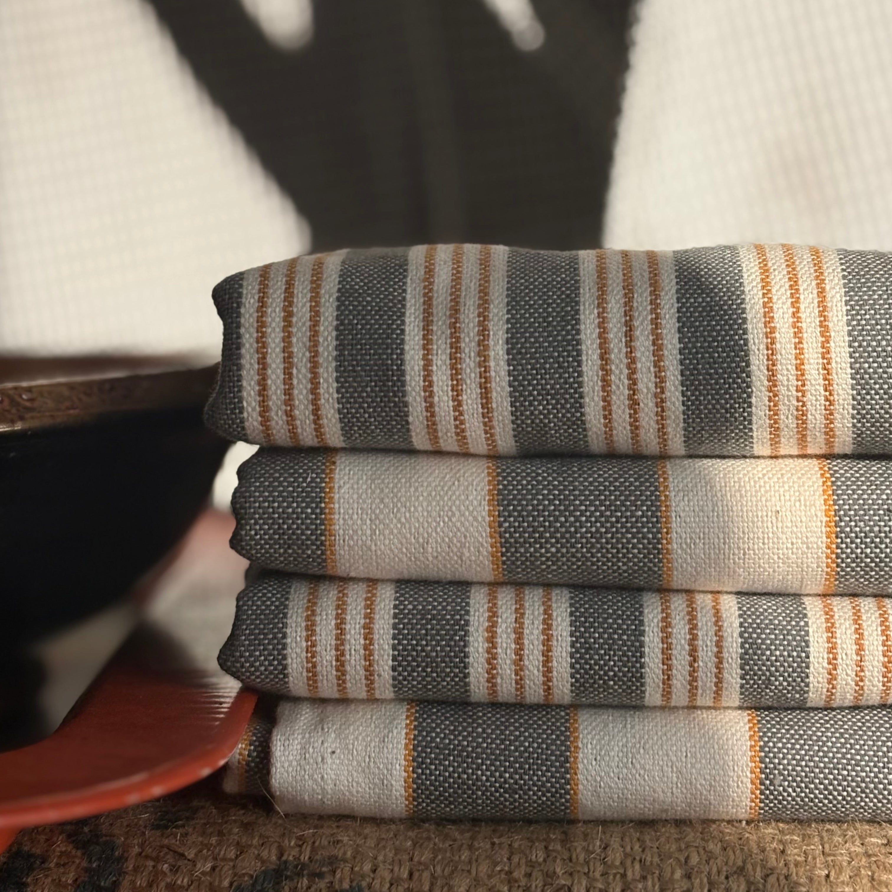 Stack of folded striped fabric on a textured surface