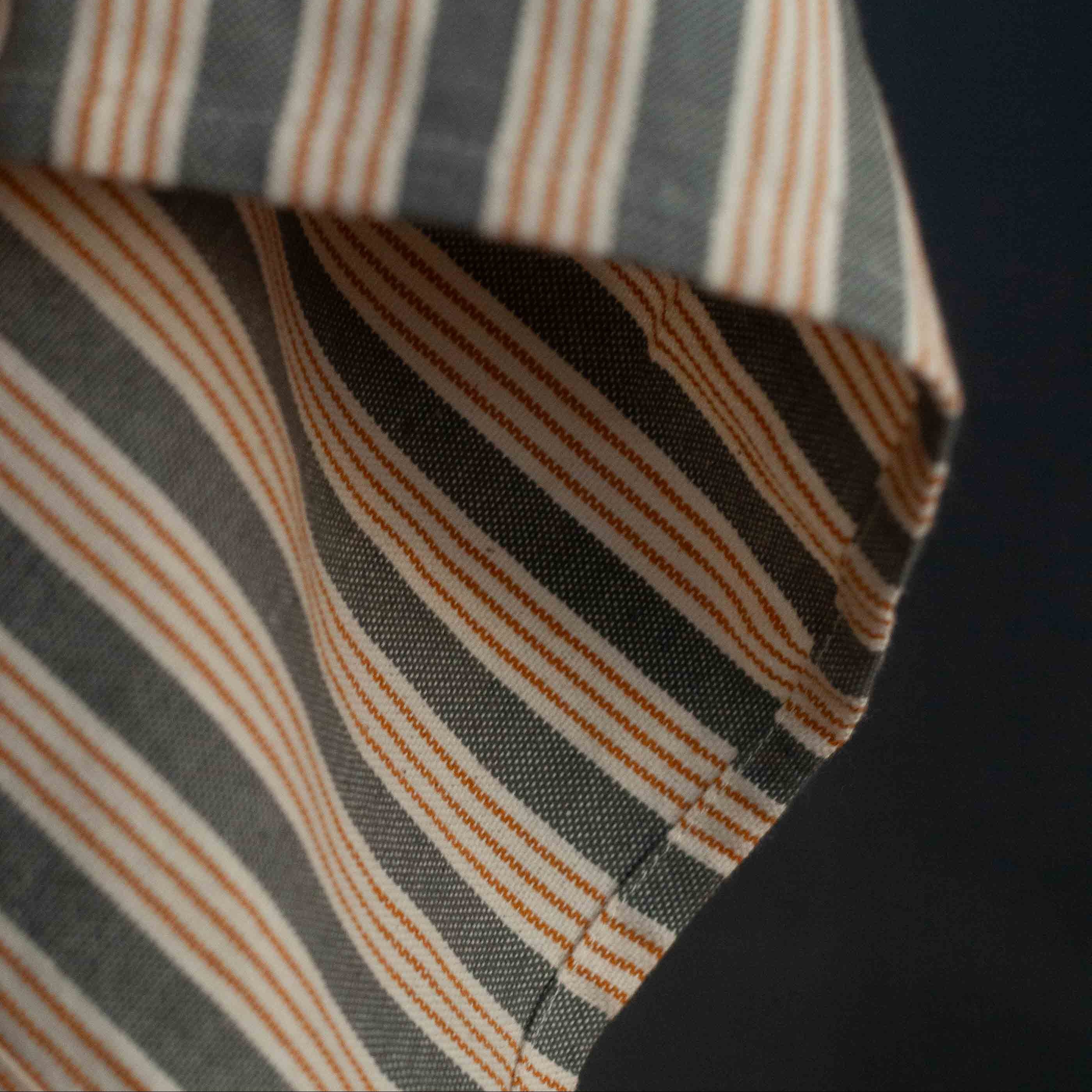 Close-up of a striped fabric with brown and gray pattern on a dark background