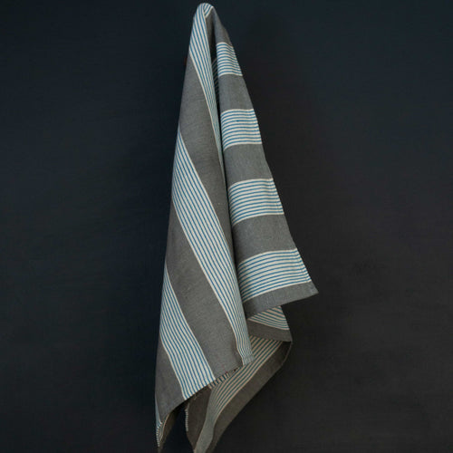 Striped towel hanging against a dark background