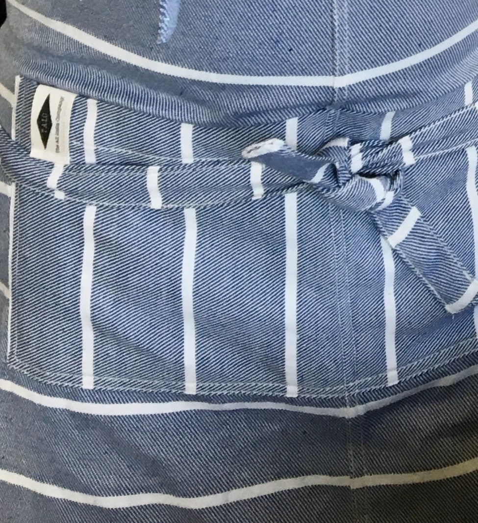 Close-up of a blue and white striped apron with a knot at the waist.
