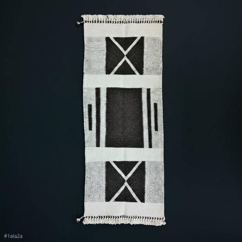 Textile with black and white geometric pattern on a dark background